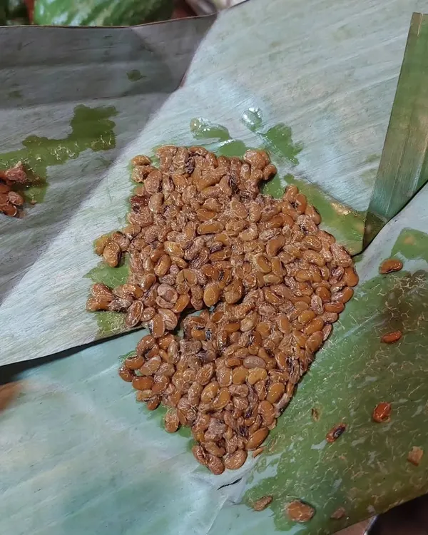This is Axone, or fermented soybeans, a key ingredient in Naga cuisine. It has a strong, pungent aroma and adds a deep, savoury flavour to pork and fish curries.