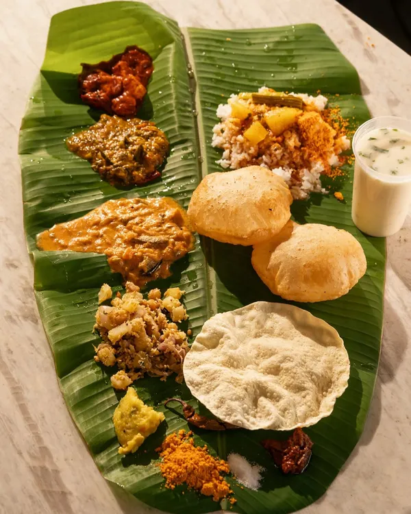 A traditional South Indian meal served on a banana leaf. This overhead shot captures the variety of colors, textures, and dishes in a single frame.