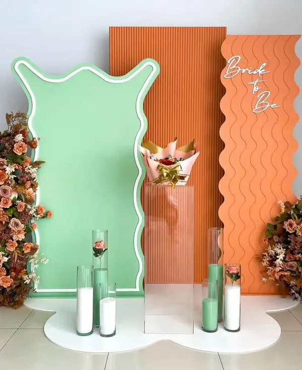 A modern and artistic "Bride to Be" setup. The abstract shapes, wavy panels, and a unique color combination of mint green and terracotta create a trendy and high-fashion look.