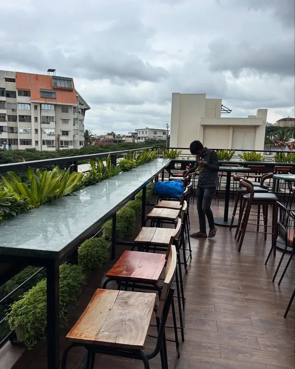 The rooftop bar at Masala Martini in Bengaluru, where we added a line of planters to create a green border with a city view. Our ongoing plant care ensures the space remains fresh, soft, and inviting for guests.