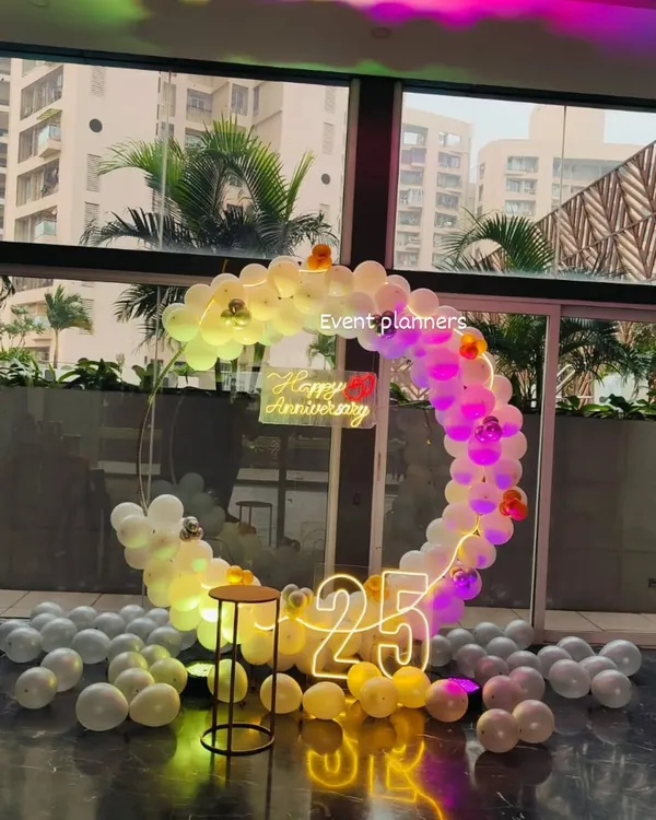 Here is another view of the 25th anniversary setup, showing how the circular balloon arch and light-up numbers create a beautiful focal point. I used a mix of white, yellow, and silver balloons to match the silver anniversary theme.