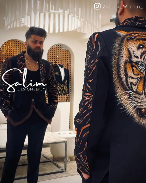A client admiring his reflection in a custom jacket featuring a large, hand-painted tiger on the back. The design extends to tiger stripes on the sleeves, creating a truly fierce and artistic statement.