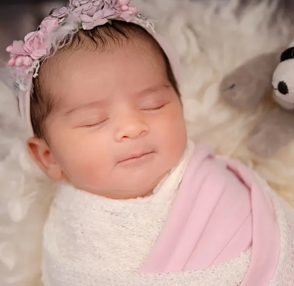A gentle smile on a sleeping angel's face. This close-up captures the pure bliss and innocence of a newborn's dreams.