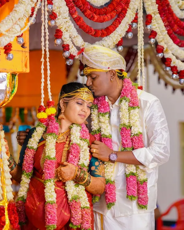 A tender moment during a South Indian wedding, where the groom kisses the bride's forehead. This shot captures the love and blessings of the ceremony.
