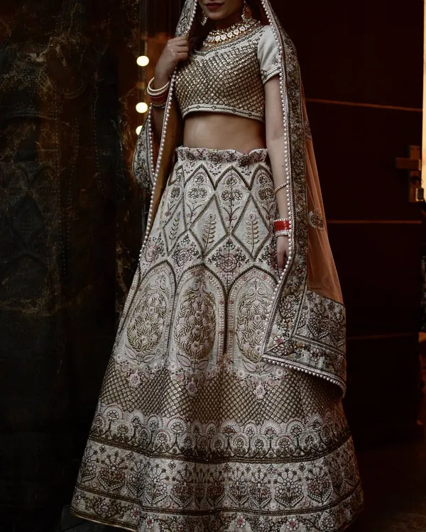 This is a full-length view of a bride wearing one of my rental jewellery sets. The Kundan choker and matching earrings add a layer of grandeur to her beautiful ivory and gold lehenga, creating a timeless and elegant bridal profile.