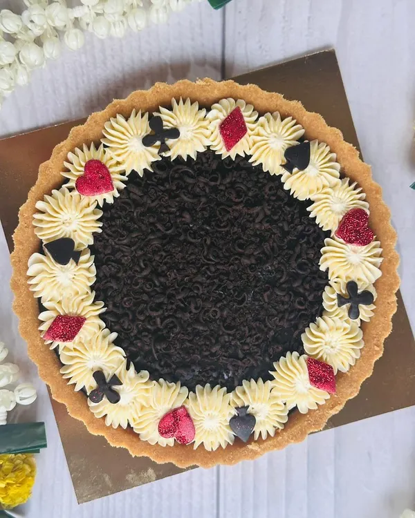 For Diwali card parties, I designed this special chocolate tart. It features a rich chocolate filling and is decorated with buttercream and edible card suit symbols for a festive touch.
