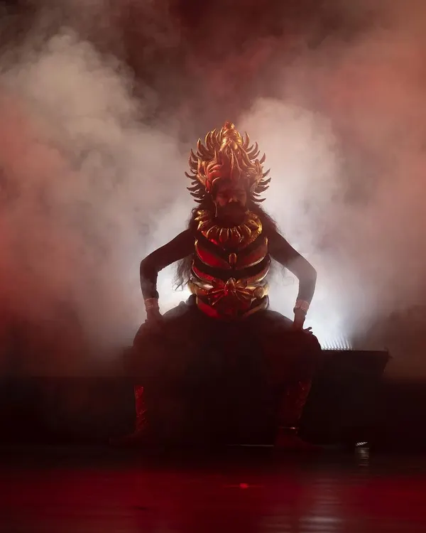 A dramatic silhouette of a character from our 'Krishna' production, using powerful backlighting and smoke to create an aura of mystery and divinity. This is an example of the professional theatrical elements we incorporate into our shows.