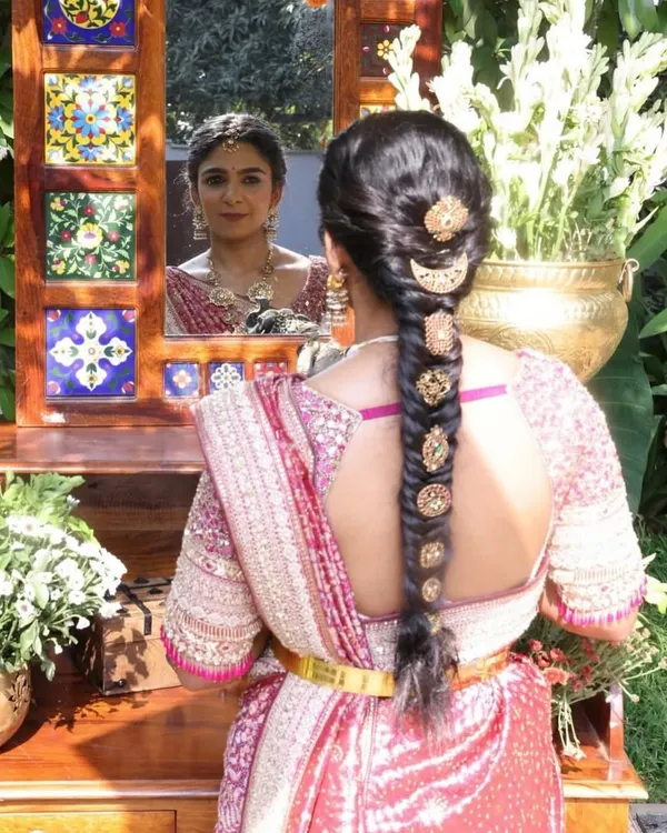 A beautiful back view showcasing the intricate details of this custom blouse. The unique cut and delicate embroidery are perfectly complemented by the traditional braided hairstyle.