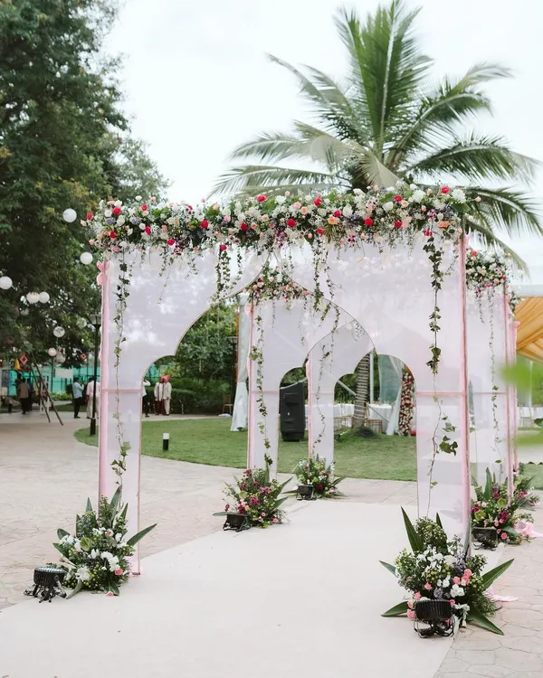 Your wedding journey begins with the first step inside. I designed this elegant entrance with modern arches, sheer drapes, and cascading florals to give guests a breathtaking welcome.