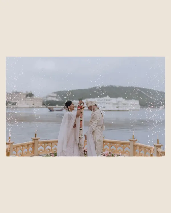 A breathtaking varmala ceremony at The Leela Palace, set against the serene waters of Udaipur. This moment encapsulates the grandeur and romance of a destination wedding, where ancient traditions meet majestic backdrops.