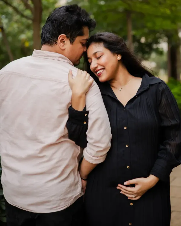 A tender moment between an expecting couple during their outdoor maternity session. The natural setting and their close embrace highlight their connection.