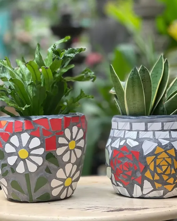 Our handmade mosaic planters add a pop of color that lasts all year. This pair features hand-cut ceramic tiles arranged in floral patterns on a terracotta base, each one a unique piece of art.
