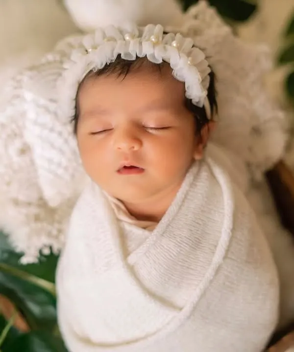 This classic swaddle keeps the baby snug and content. I styled this shot with a soft lace headband and fresh green leaves for a pure and natural feel.