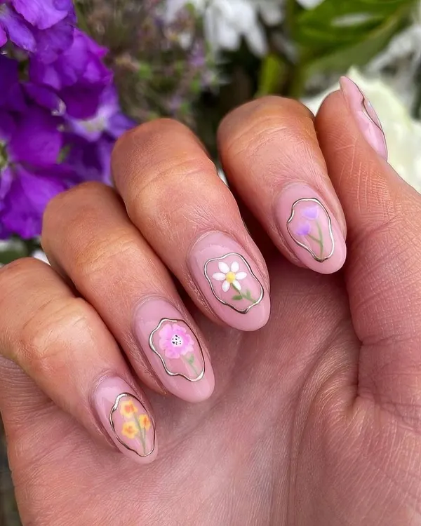 These "floral window" nails are so delicate and unique. Each nail features a tiny, hand-painted flower framed by a thin gold chrome line on a sheer pink base, creating a beautiful stained-glass effect.