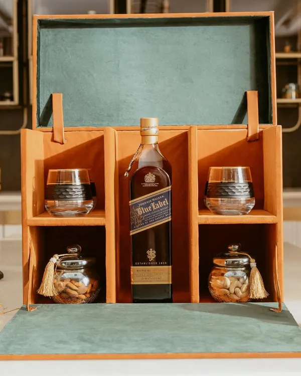 This is our signature luxury whiskey hamper, a statement of true sophistication. It features a premium whiskey of your choice, two crystal glasses, and jars of fine nuts, all housed in a beautiful, handcrafted leather-finished box. It is the perfect gesture for esteemed clients or to celebrate a major corporate milestone.