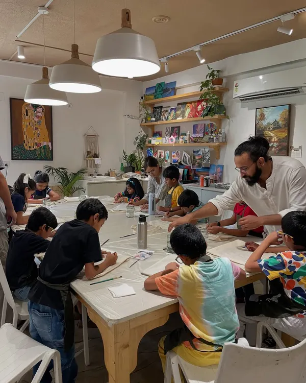 Here is one of our artist mentors guiding a group of young children during a sketching session. We believe in supporting and encouraging, never taking over their creations.