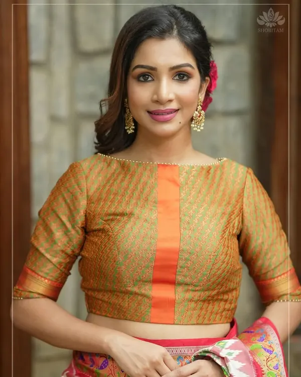 This elegant boat-neck blouse is crafted from a beautiful woven fabric with a central orange panel. The three-quarter sleeves and classic cut make it a timeless piece.