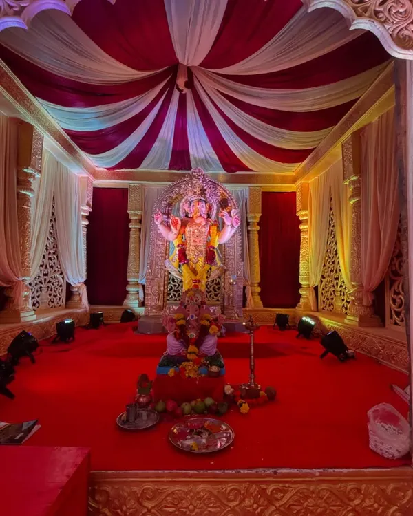 A grand and traditional mandap setup for Ganesh Chaturthi. I used a classic red and white color scheme with elegant draping, detailed pillars, and focused spotlights to make the Ganpati idol the center of attention.