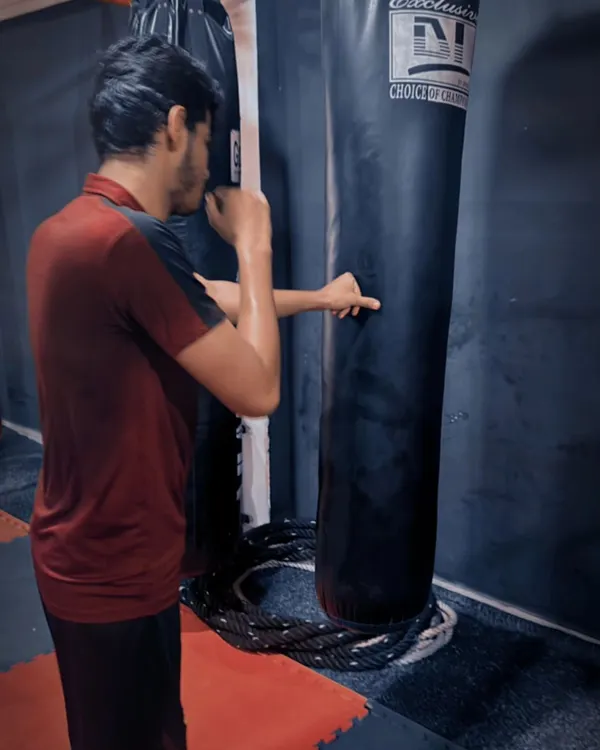 Focused and determined. A student practices his punching technique on the heavy bag, a perfect example of the dedication we cultivate in our fighters.