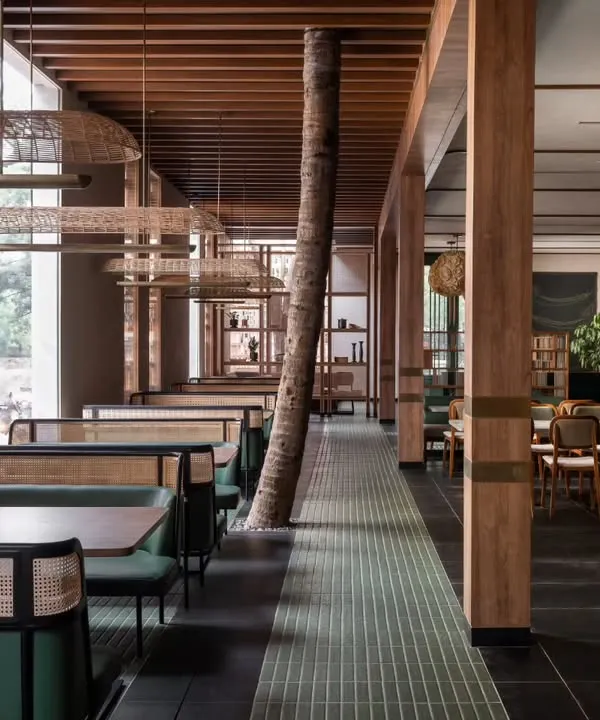 We designed the Ishtaa restaurant interior around the existing trees, making them the heart of the space. This approach to biophilic design brings a natural calm and soul to the dining experience, blending the indoors with the outdoors through custom cafe seating and warm, natural materials.