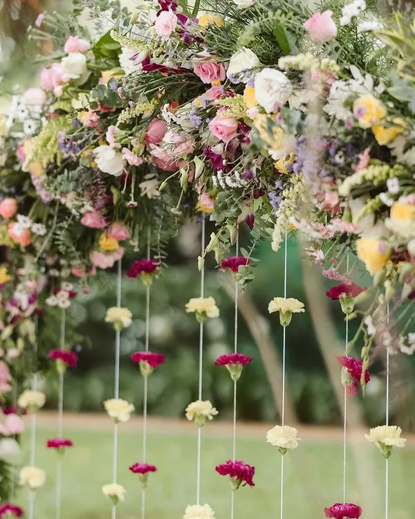 A close-up of this beautiful floral arch we created for an outdoor Haldi ceremony. The mix of pastel and bright flowers with hanging carnations created a dreamy and picturesque backdrop under the trees.