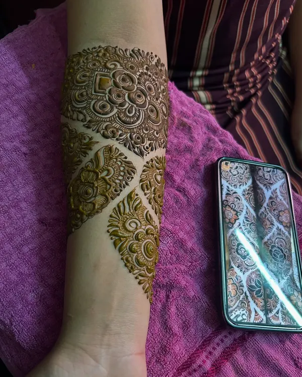 A close-up of an engagement mehendi, showing the intricate patterns on the forearm. The design is inspired by a reference photo provided by the client.