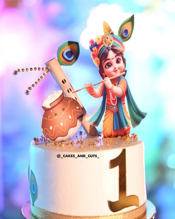 A vibrant first birthday cake with a Little Krishna theme, complete with a flute and peacock feathers. We teach how to use edible prints and fondant to create detailed characters.
