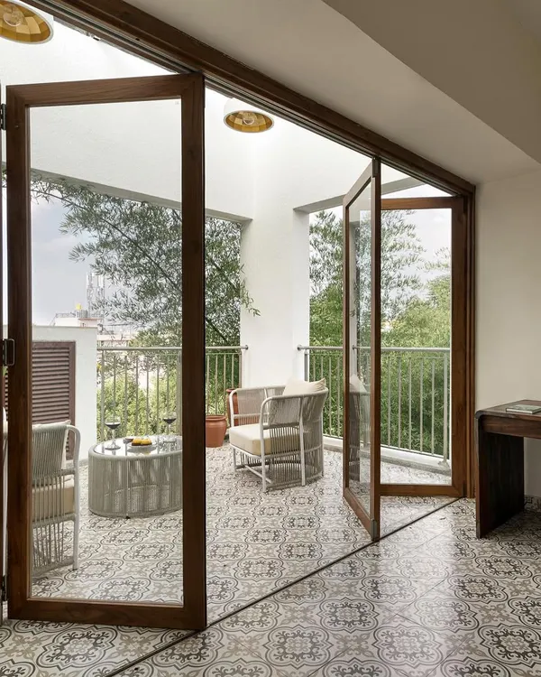 We transformed a laundrette and small balcony into this stunning home office, using a sliding folding door to open the space to a serene, green view.