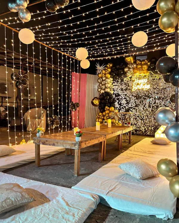 We now offer complete event solutions, including decorations. This beautiful setup features floor seating, fairy lights, and a sequin backdrop, creating a glamorous and comfortable ambiance for a New Year's party or any special occasion.