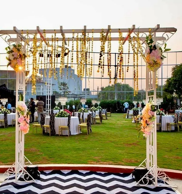 An overview of the stunning outdoor setup for the 60th birthday bash. We designed the entire space with a hanging floral installation, themed guest seating, and a striking chevron-patterned walkway.