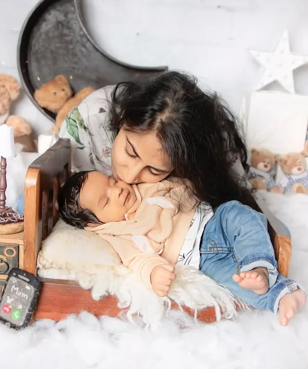 A mother's love is the most precious thing in the world. We captured this tender kiss during a newborn session in our studio, using a dreamy, cloud-like setup with soft lighting to create a truly magical memory.