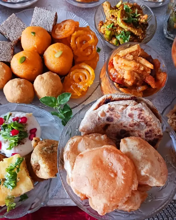 A closer look at the breads and sweets from my vegan 56 Bhog. This platter includes classic Indian sweets like jalebi and laddoos, alongside savory pooris and puranpoli, all made without dairy.