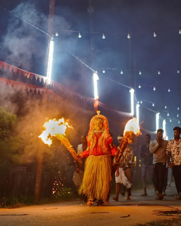 This is the moment a Bhoota Kola performer, embodying a divine spirit, emerges into the night. I captured this using only the light from the flaming torches to preserve the raw, intense atmosphere of the ritual. It’s moments like these, full of energy and faith, that I strive to document.