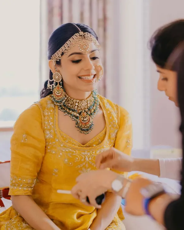 A radiant bride in her grandmother's heirloom yellow poshak for her Udaipur wedding. We kept the makeup minimal and glowing to honor the tradition and the beautiful color.