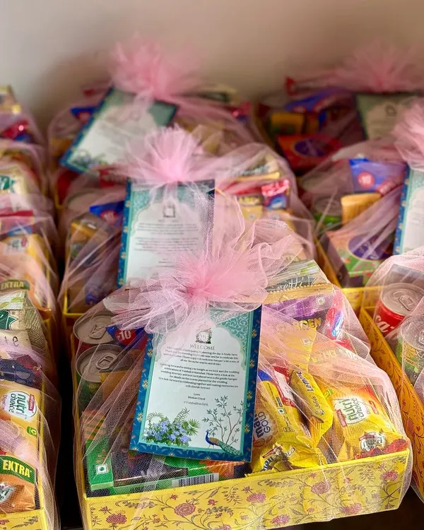 A warm welcome for your wedding guests! These room hampers are filled to the brim with snacks and drinks, all wrapped in delicate pink tulle with a personalized welcome note.