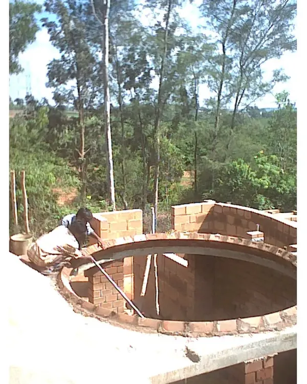 A mason skillfully constructing a circular brick dome for the Professor's Residence. This showcases the high level of craftsmanship involved in our projects and our use of traditional building techniques like domes and vaults.