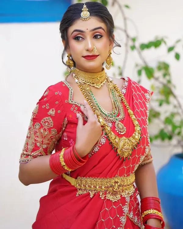 A beautiful red lehenga saree drape, perfect for a sangeet or engagement ceremony. The pallu is styled to create a graceful fall while being securely pinned.