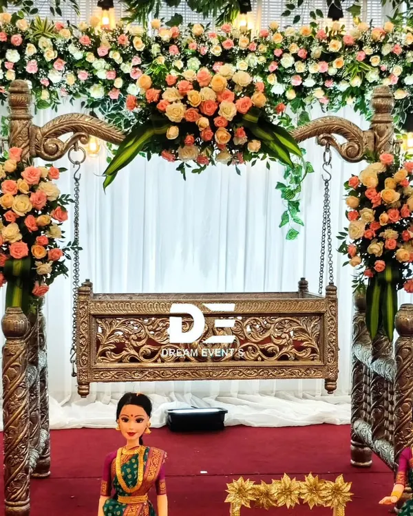 We believe a naming ceremony should be as precious as the new arrival. This elegant setup features an intricately carved wooden jhoola (cradle) framed by an arch of fresh peach and white roses, creating a dreamy and photogenic centerpiece for the celebration.
