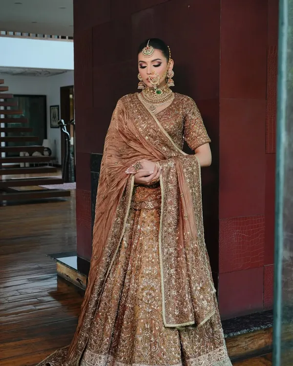 For this look, I personally draped the dupatta to create a royal and elegant silhouette. The rich brown Akriti by Shakun lehenga is perfectly complemented by the heavy polki and emerald jewellery from Shri Paramanijewels.