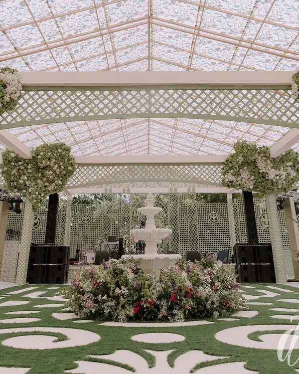 The centerpiece of our spring luncheon design was this beautiful three-tiered fountain surrounded by a bed of colorful flowers. The custom grass-and-paver style flooring and heart-shaped floral trees add a touch of whimsy and romance.