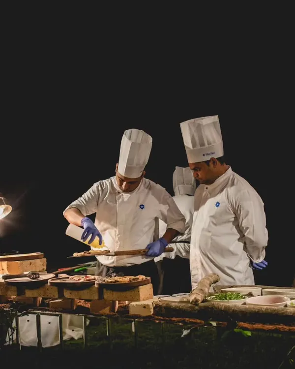 Our chefs are the heart of the experience, seen here preparing dishes at a live station. We go beyond standard counters to deliver extraordinary concepts like a Fromage Bar and modern Indian Wood-fired Kulchas.