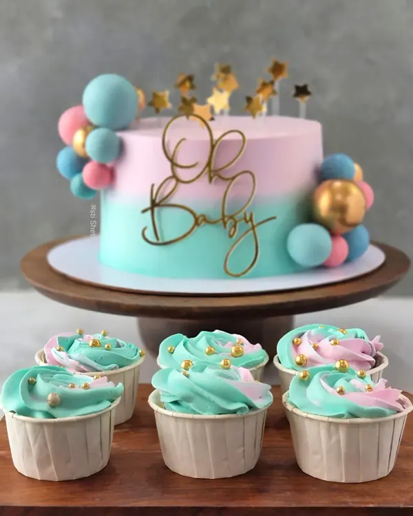 This "Oh Baby" shower cake is a perfect example of my custom, fondant-free work. The pastel pink and blue ombre effect is created with delicate whipped cream, complemented by matching cupcakes for a complete dessert table.