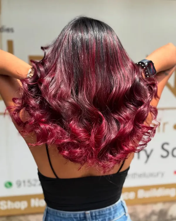 A stunning Redwine Balayage that blends seamlessly from a dark base to vibrant red ends. This look is styled in waves to show off the rich, dimensional colour.