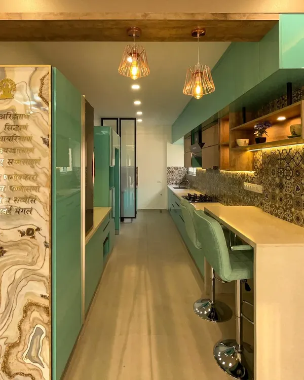 This parallel kitchen is designed for efficiency and style. The long countertop provides ample workspace, while the aqua cabinetry and patterned tiles add a burst of personality. All woodwork is BWP ply for maximum durability.