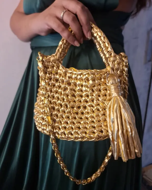 This is my showstopper, the 'Golden Girl' bag. I hand-crochet each one from metallic t-shirt yarn, making it a perfect statement piece for when you want to feel that extra bit of sparkle. It's sturdy, stylish, and made with so much love.
