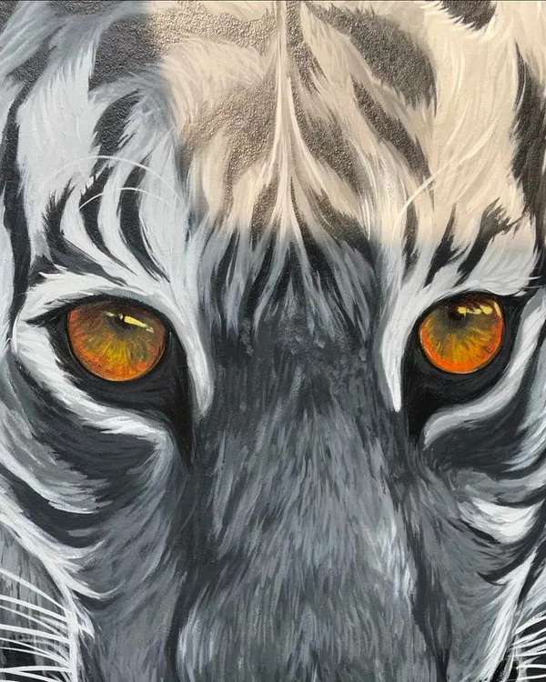 This realistic mural of a white tiger, created for a clubhouse entrance, captures the power and intensity of the animal. We specialize in creating such impactful, lifelike wildlife art that becomes a centerpiece for any space.