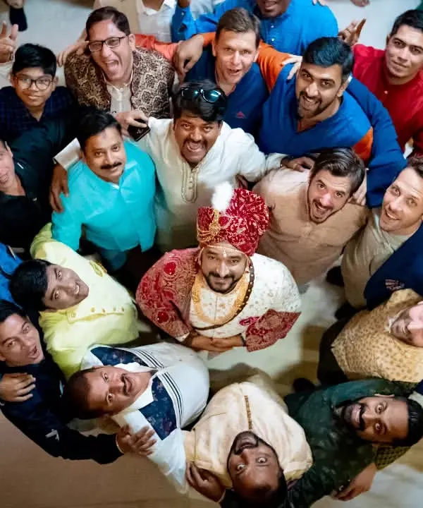A fun, top-down shot of the groom surrounded by his groomsmen, all celebrating together.
