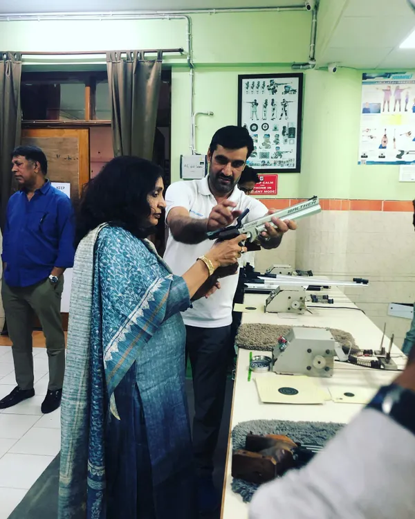 I believe in hands-on guidance. Here, I am showing a first-time shooter the correct way to handle an air pistol, ensuring she feels safe and confident from the very first moment.