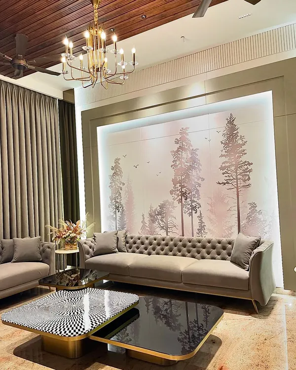 This living room in Ambala is the essence of quiet luxury. We designed this space with a custom nature-inspired wallpaper, a classic tufted sofa, and a statement chandelier to create a grand yet serene atmosphere for the family.