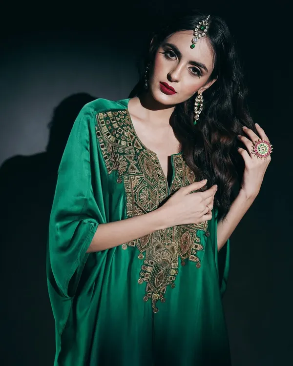 In this studio portrait, I used dramatic, low-key lighting to emphasize the luxurious feel of the emerald green kaftan. The focus is on the intricate gold embroidery and the model's commanding presence, creating a powerful image for a designer campaign.